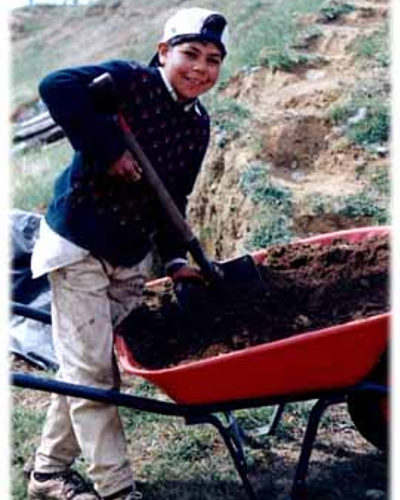 Our Vision - Pasos Sureños -- Ali helping - look at shoes